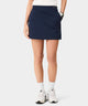 Front view of the TX Air Skirt in dark blue, worn by a golfer, featuring a wide waistband with subtle Macade branding, discreet front pockets, and a streamlined, modern silhouette for active and everyday wear.