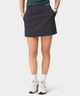 TX Air Skirt in dark grey shown on a woman golfer, featuring a wide waistband, discreet front pockets, and a streamlined, modern fit designed for comfort and versatility on and off the course.