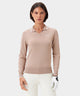 Woman wearing the Ella Knit Top in taupe, a long sleeve women's golf polo with a contrast-tipped open placket collar, sleek minimal Macade logo on the left chest, and ribbed cuffs, styled with white golf pants and a glove for a refined, modern look on the course.