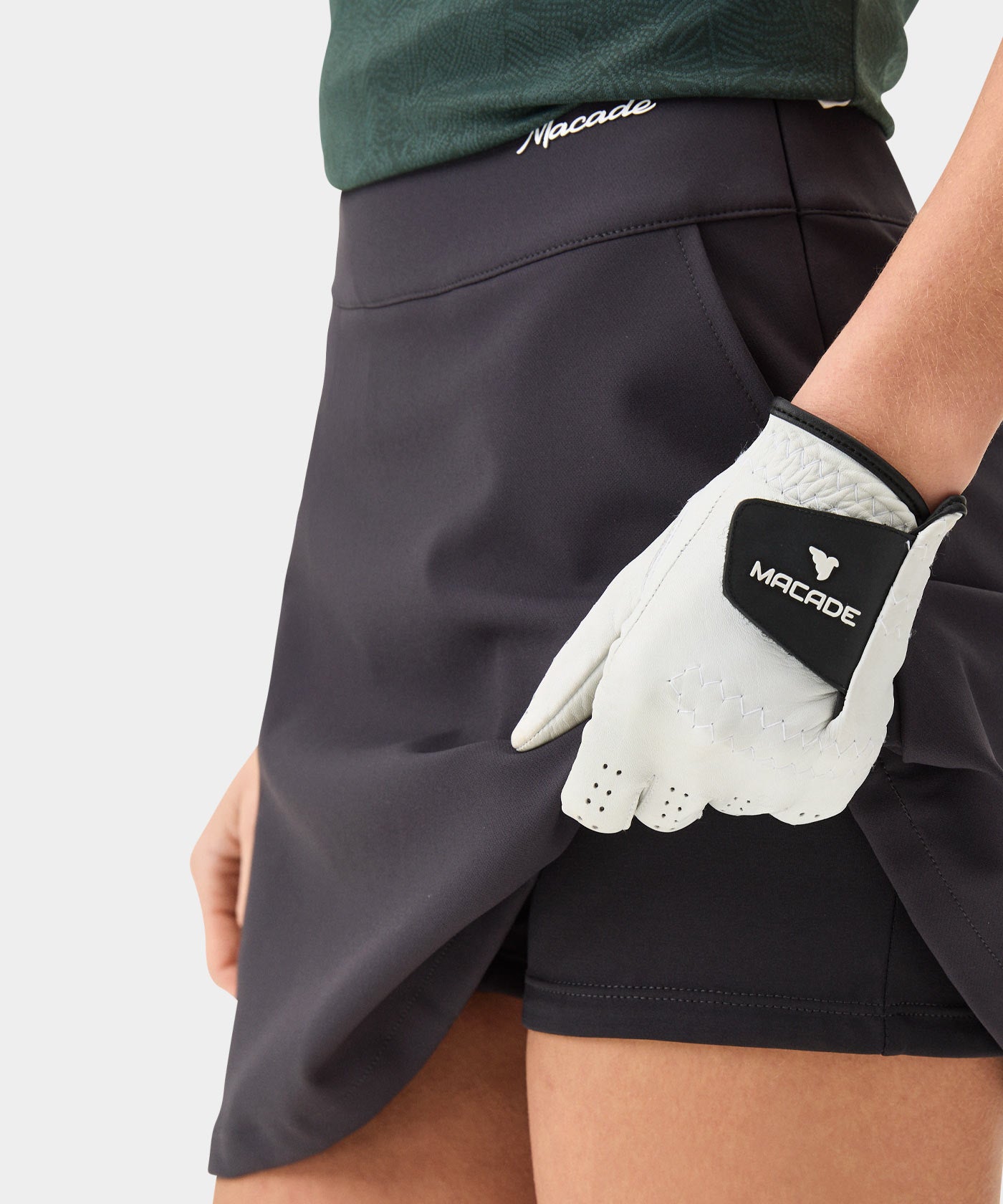 Close-up of the TX Air Skirt in dark grey, highlighting the built-in shorts for coverage, wide waistband with minimal Macade branding, and discreet front pocket, designed for confident movement on the golf course.