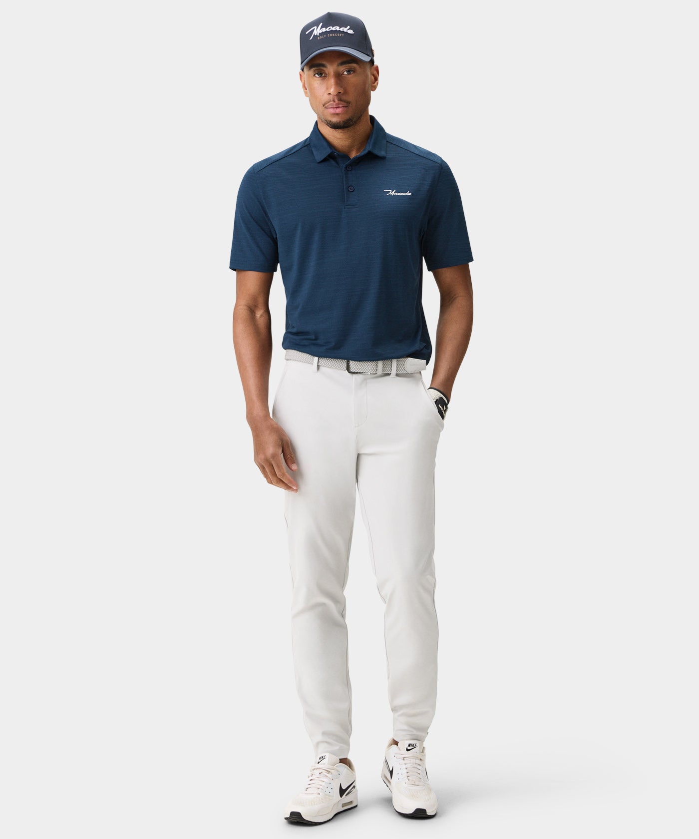 Male golfer wearing Macade Golf Four-Way Stretch Jogger in white, paired with a navy polo and matching cap, showcasing the jogger’s athletic fit, minimal branding, and modern tapered leg for a clean, versatile look suitable for both the golf course and everyday wear.