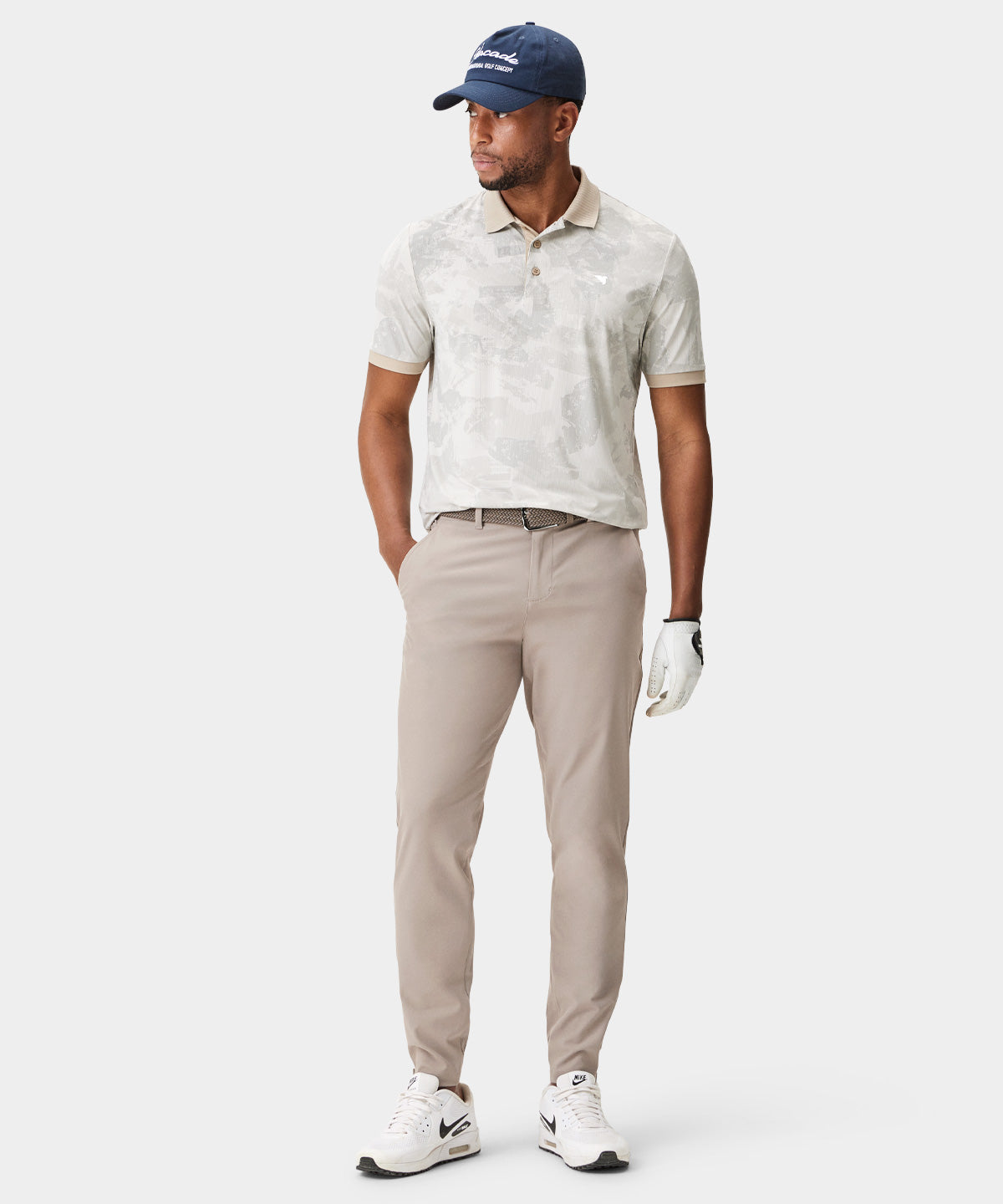 Male golfer wearing Macade Golf Four-Way Stretch Jogger in beige, styled with a patterned polo and golf cap, showcasing the jogger’s tailored fit, clean lines, and modern athletic silhouette designed for comfort and versatility on and off the course.