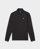 Man wearing the Macade Golf Therma Quarter Zip in black, featuring a minimalist design with a subtle chest logo, paired with light beige golf pants and a black cap for a clean, athletic look.