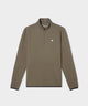 A man models the Macade Golf Therma Quarter Zip in olive green, featuring a minimalist design with a subtle chest logo, sleek tonal zipper, and modern athletic fit, styled for a refined look on the golf course.