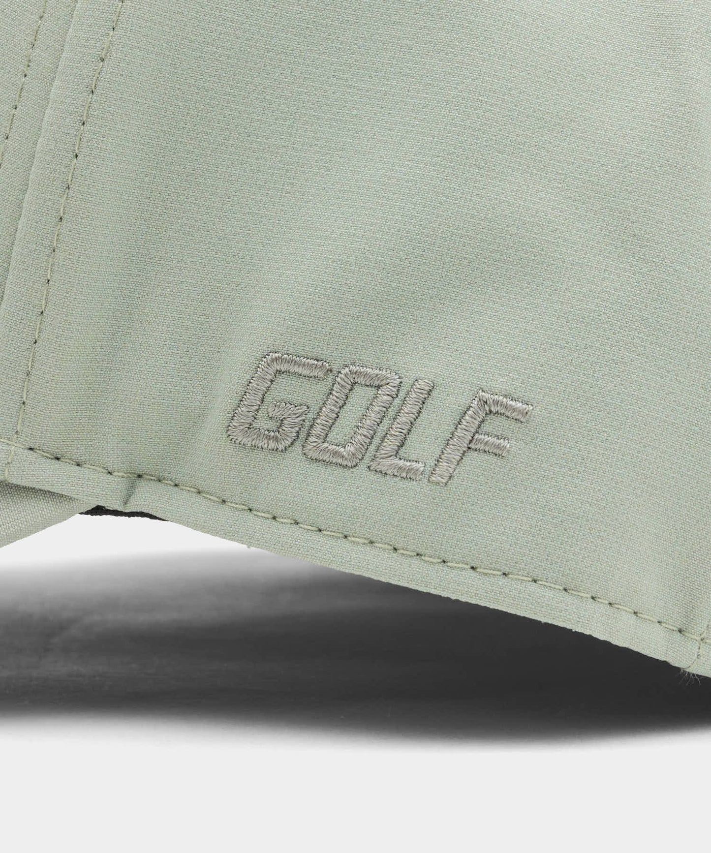 Close-up of the Range Snapback by Macade Golf in jade green, highlighting the subtle GOLF embroidery and premium stitching on the lightweight, breathable fabric.