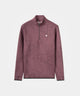 Man wearing the Macade Golf Therma Quarter Zip in mauve with a subtle tonal leaf pattern, styled with black golf pants and a black cap for a refined, modern look on or off the course.