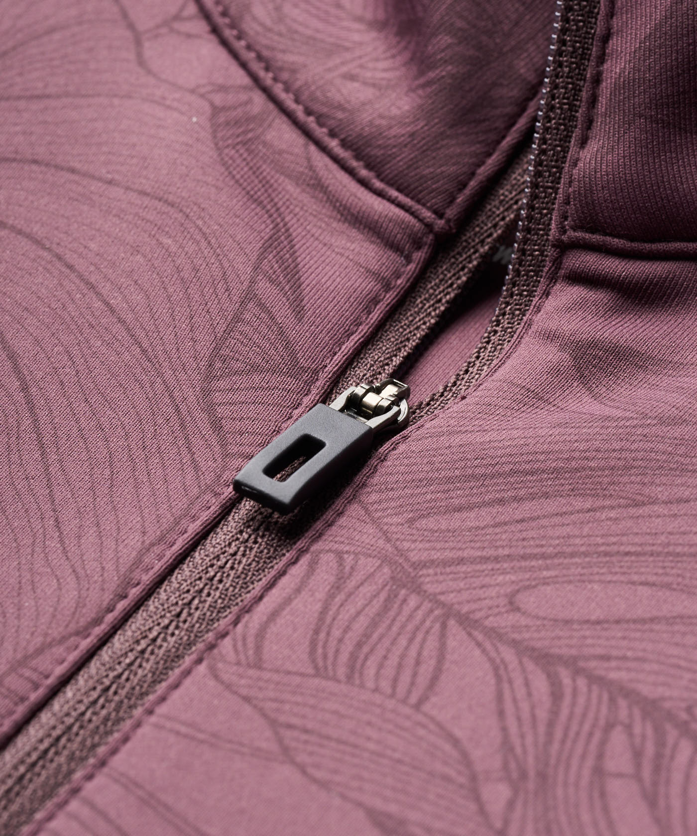 Close-up of the Therma Quarter Zip by Macade Golf in mauve, highlighting the premium zipper and smooth, high-stretch fabric with subtle tonal pattern detailing for a refined, modern finish.