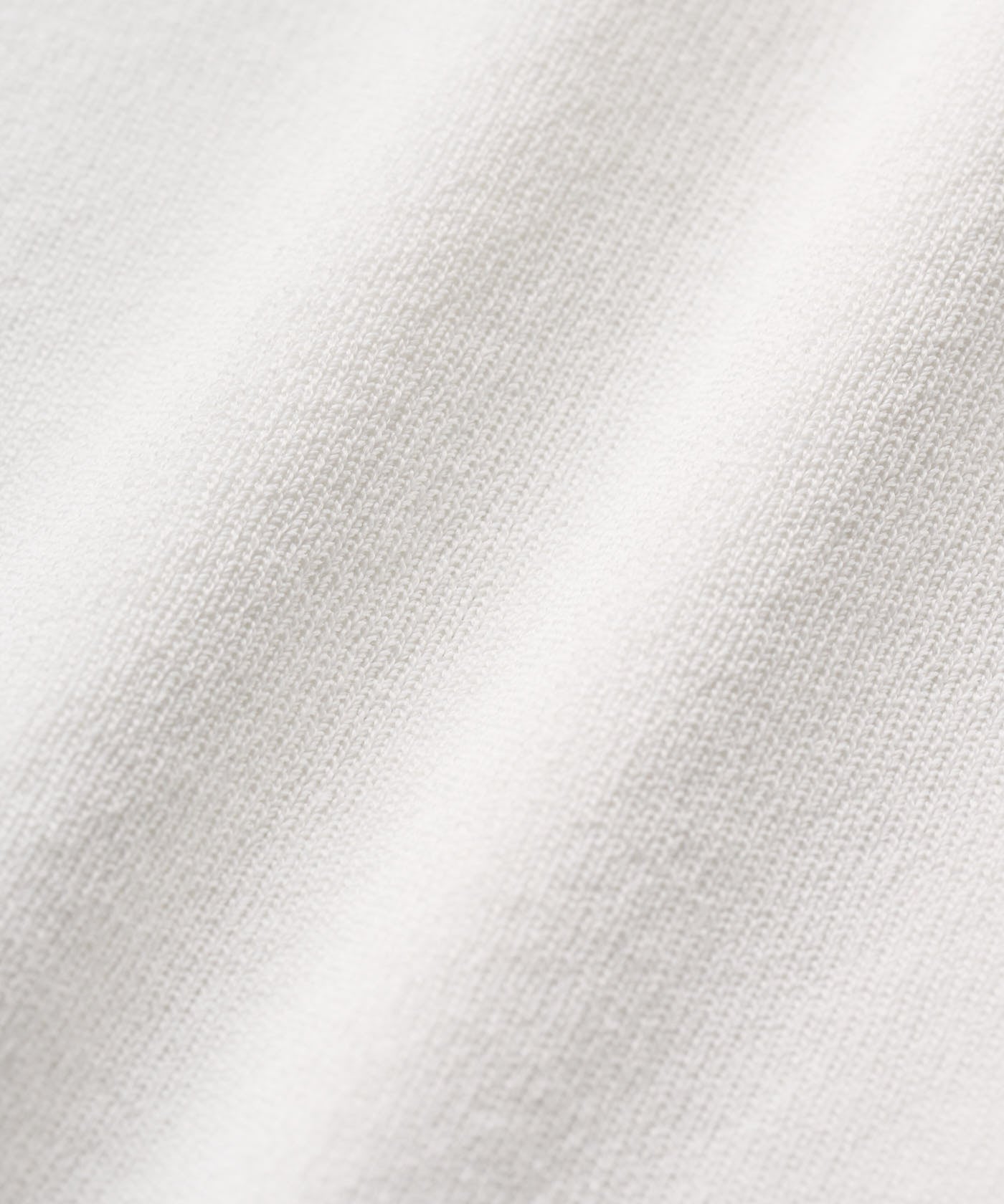 Detail of the Ella Knit Top in white, showcasing the fine knit texture and smooth, breathable viscose blend fabric.