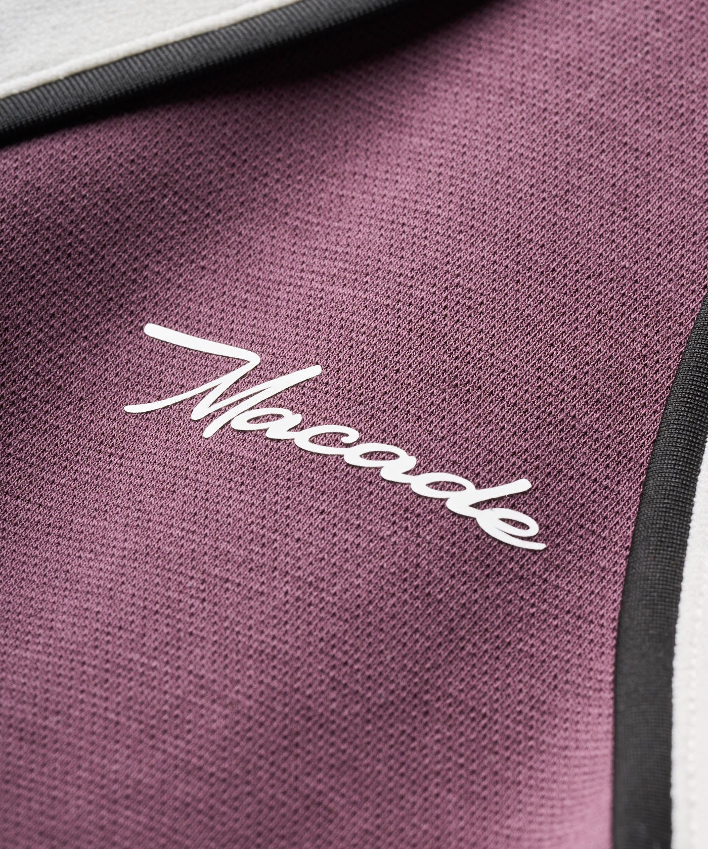 Close-up of the Ava TX Flow Dress in mauve, highlighting the sleek and minimal Macade branding, soft knit texture, and contrast piping detail.