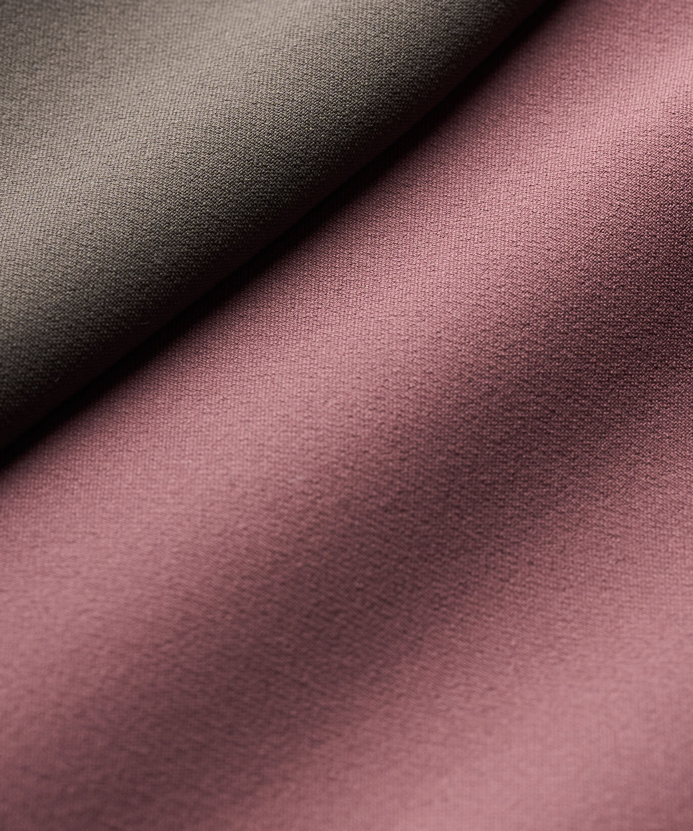Close-up of the premium polyester and spandex fabric used in the Macade Golf Storm Wind Jacket, highlighting its smooth, soft shell texture in mauve and taupe colors.
