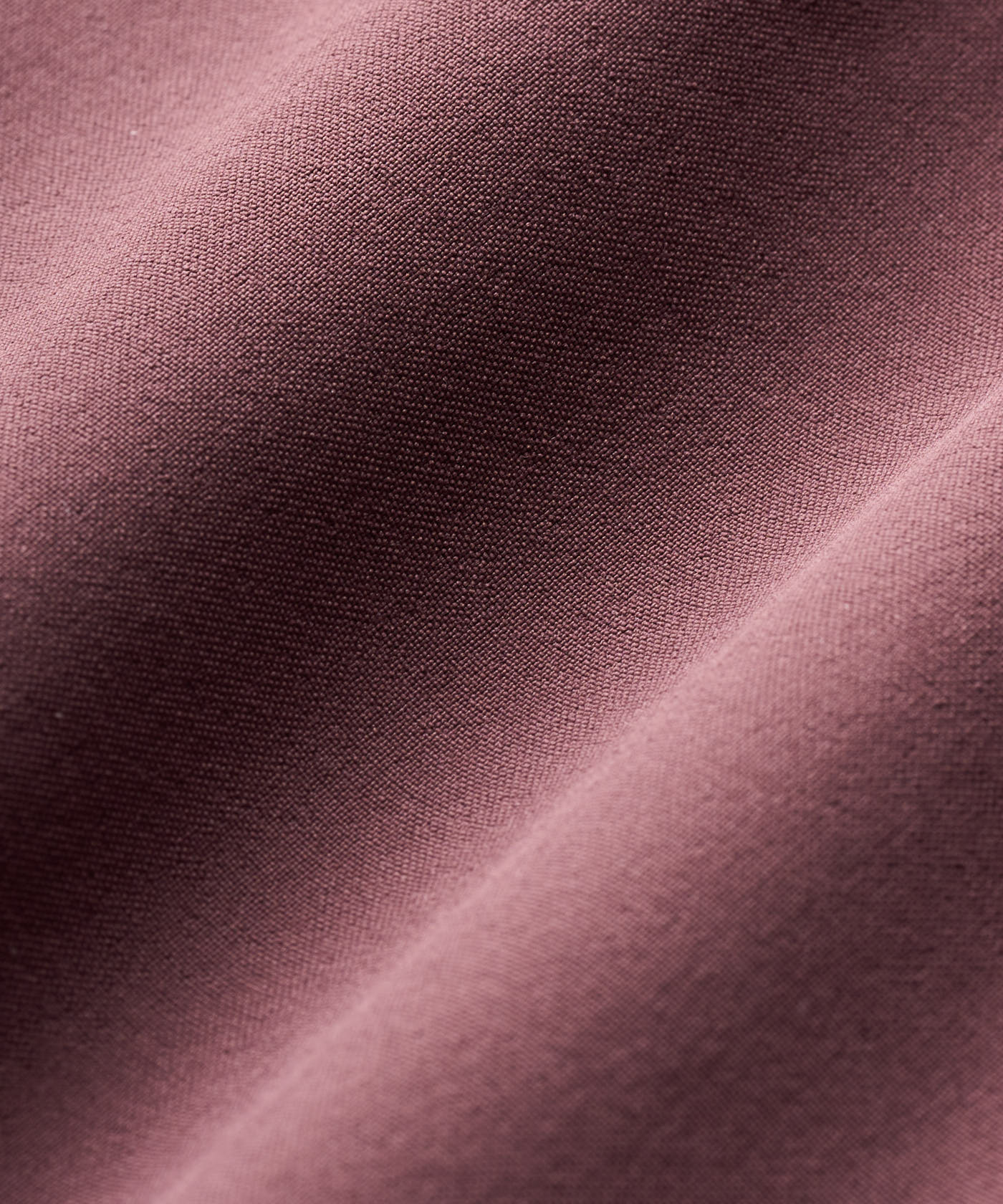 Macro shot of the mauve Flex Shorts fabric by Macade Golf, highlighting the smooth, tightly woven texture and premium polyester-spandex blend for a soft, flexible feel.