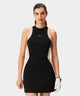 Woman golfing in the Macade Golf Inez Sleeveless Dress in black with beige side panels, featuring a fitted, athletic cut and minimal branding, designed for effortless movement and modern style on the course.