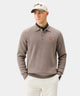 Man on a golf course wearing a Macade Cashmere Blend Knit Polo in cedar, featuring a soft knit texture and bold Stay on Course embroidery across the back, styled with a white cap and golf glove tucked into his pocket.