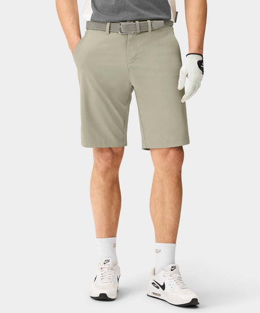 Front view of a man wearing Macade Golf Four-Way Stretch Shorts in light olive, styled with a woven belt and golf glove, highlighting the tailored fit, functional pockets, and smooth, breathable fabric ideal for golf and everyday wear.