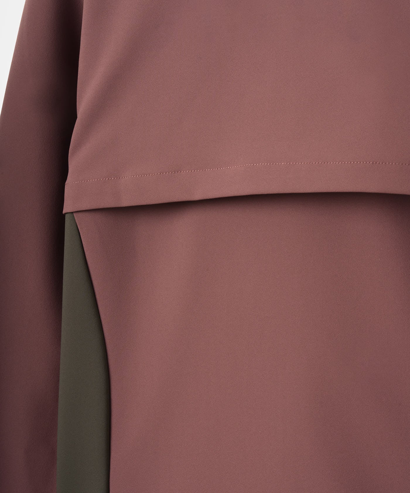 Close-up of the mauve and olive color-blocked Storm Wind Jacket by Macade Golf, highlighting the smooth, soft shell fabric and the clean, minimalist rear ventilation flap detail.