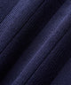Woman wearing the Ana Sleeveless V-Neck in navy, featuring a ribbed knit texture, clean v-neckline with white double trim, and a minimal Macade bird logo at the chest, paired with a white golf skirt and glove.