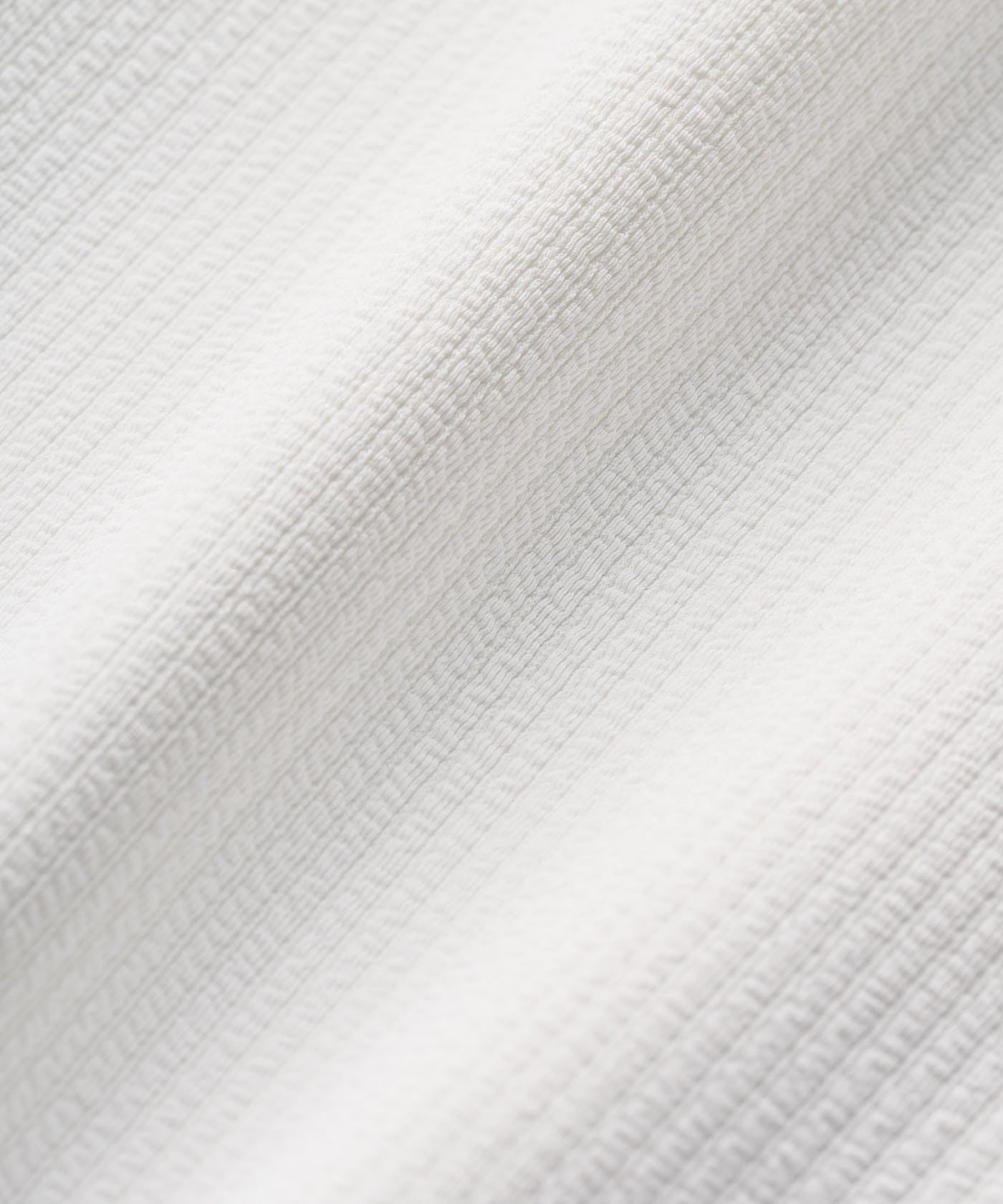 Close-up of the Cora TX Dress fabric in white, showing its lightweight, textured weave designed for breathability and moisture-wicking comfort.